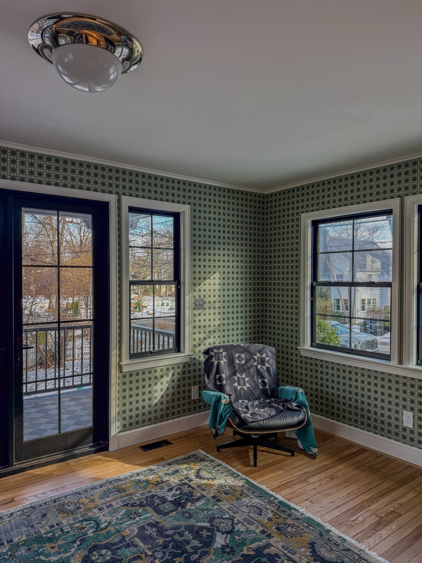 Sunroom remodel with patterned wallpaper and reading chair