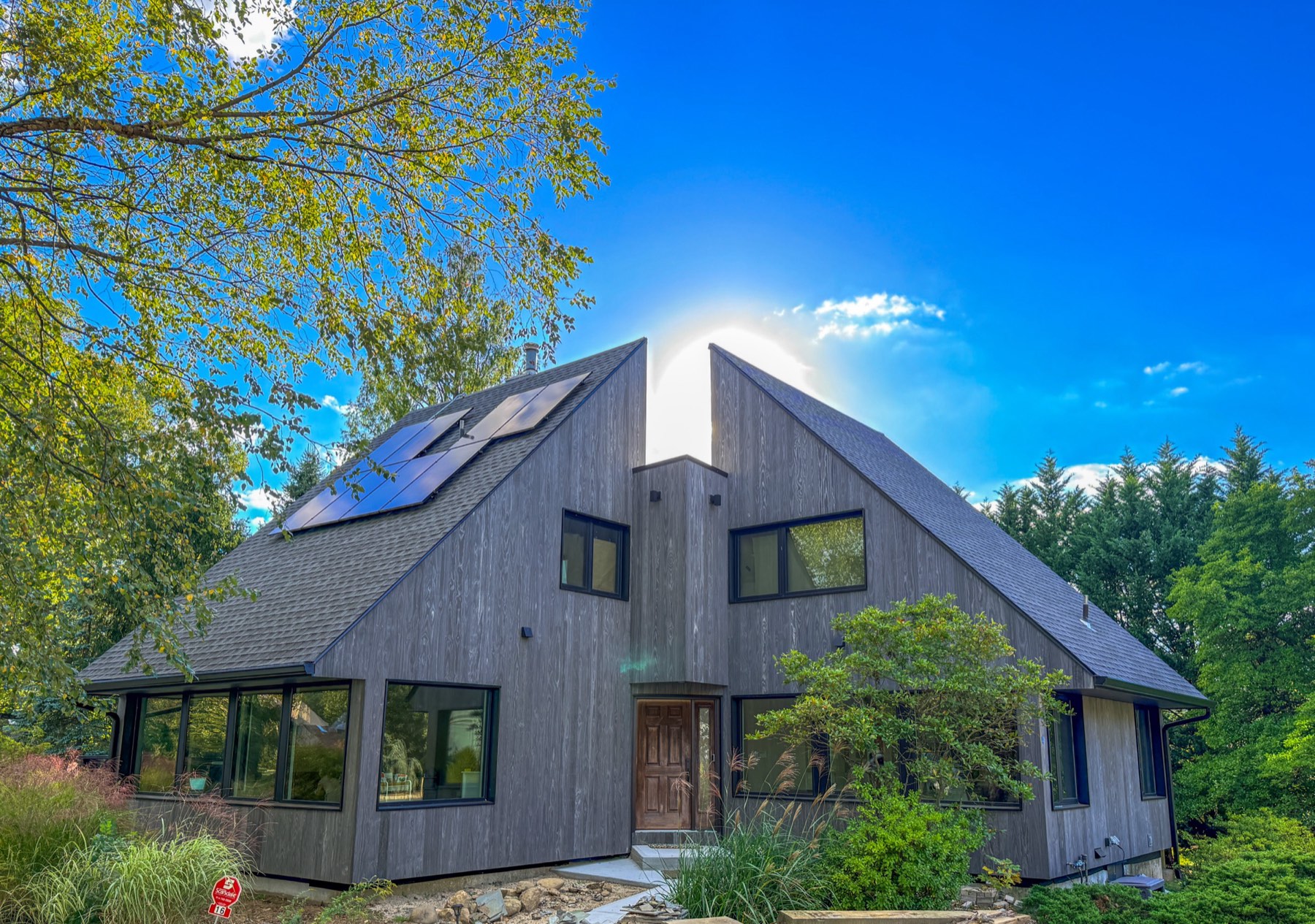 Finished custom home with weathered Accoya wood cladding and solar roof