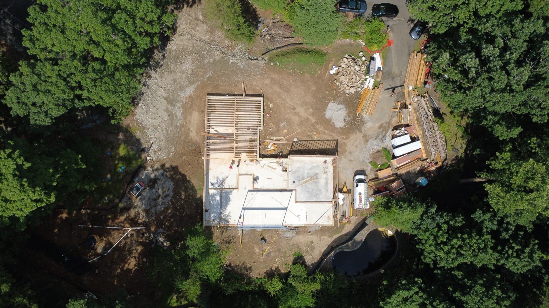 Aerial view of a foundation and concrete pour on a wooded site
