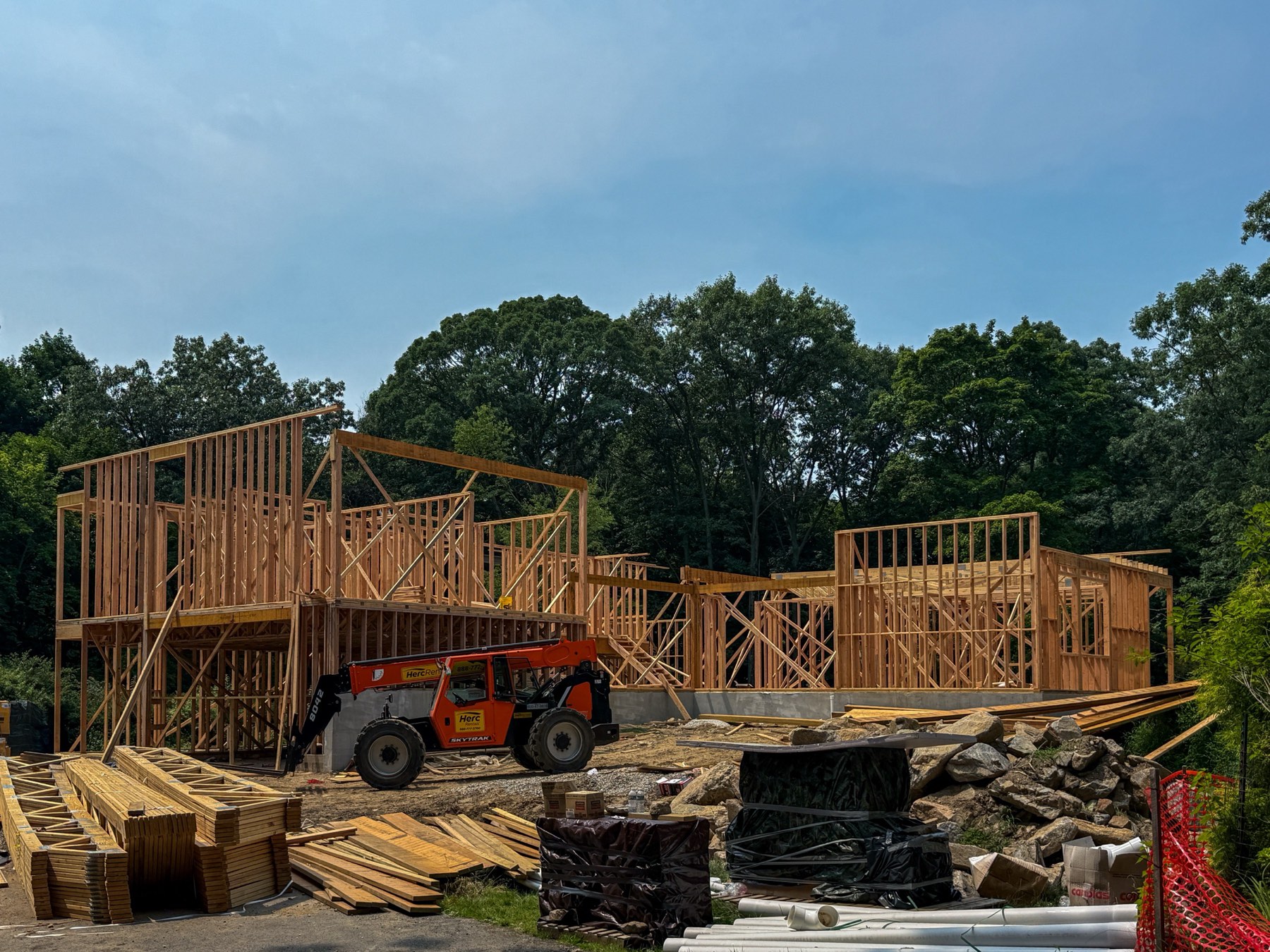 Ground-up construction site with wall framing and heavy equipment