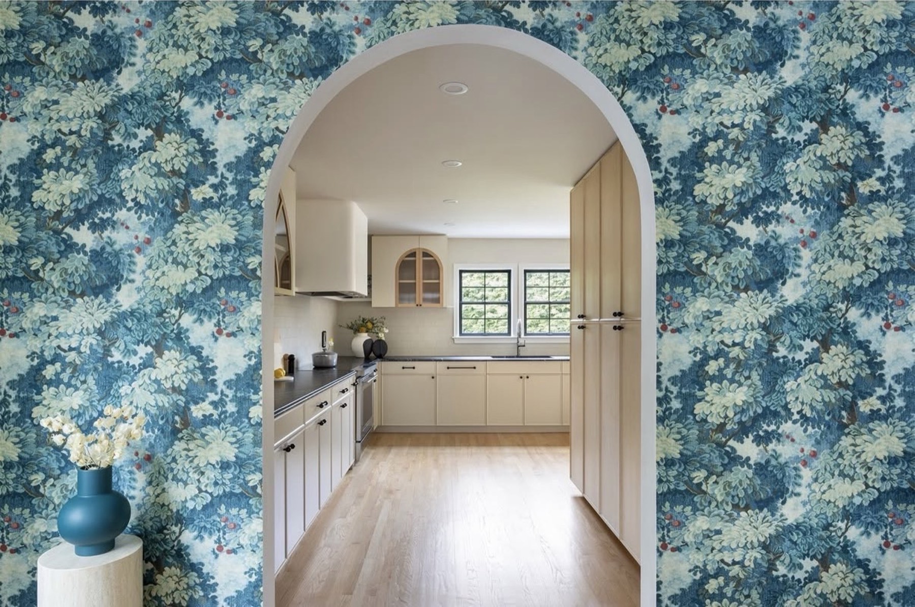 Arched wallpapered entry into remodeled kitchen