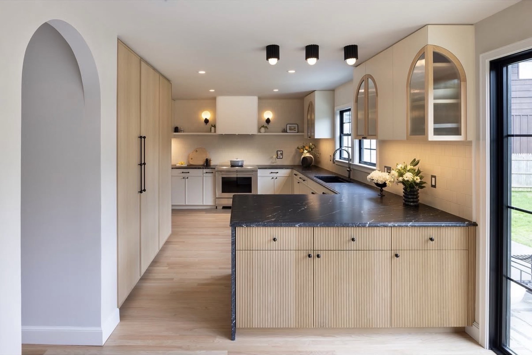 Remodeled kitchen with reeded wood island and black soapstone counters